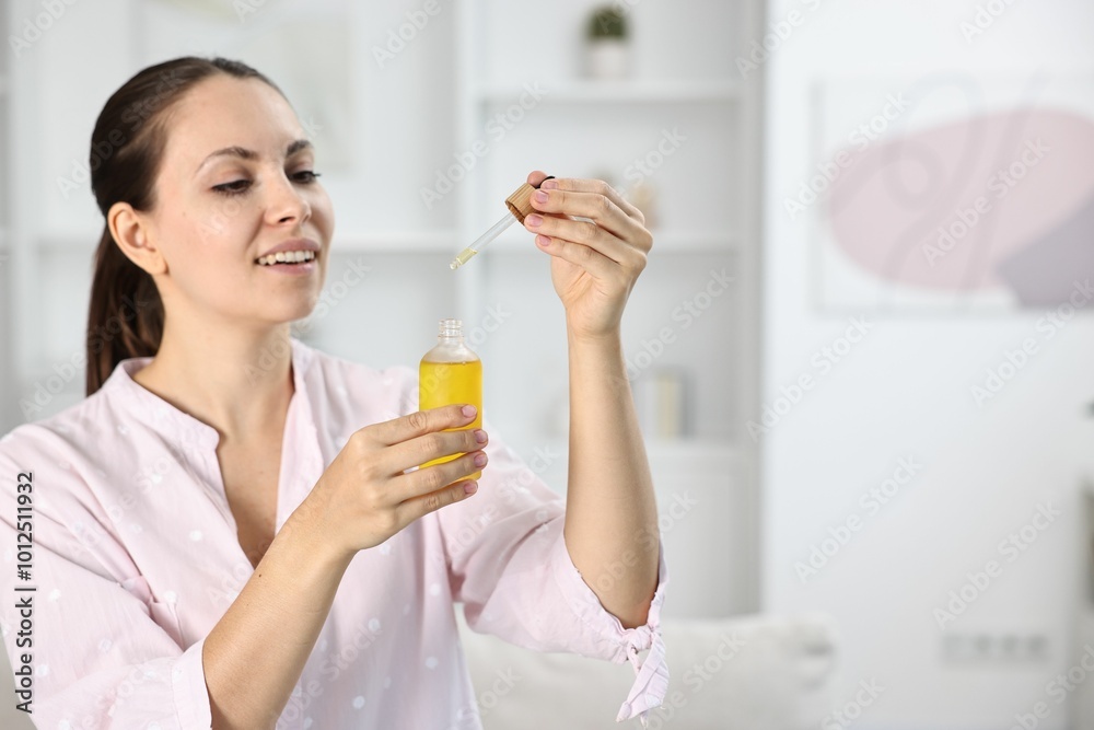 Young woman taking CBD tincture indoors, space for text Young woman taking CBD tincture indoors, space for text