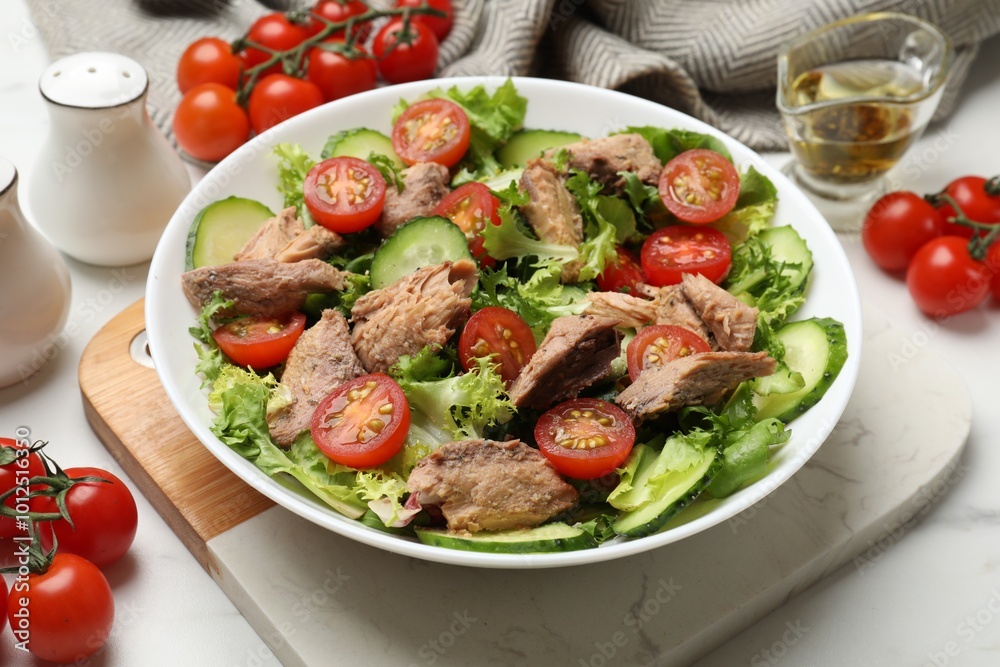Delicious fresh tuna salad on white table, closeup