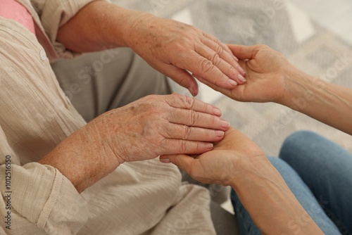 Caregiver supporting senior woman at home, closeup