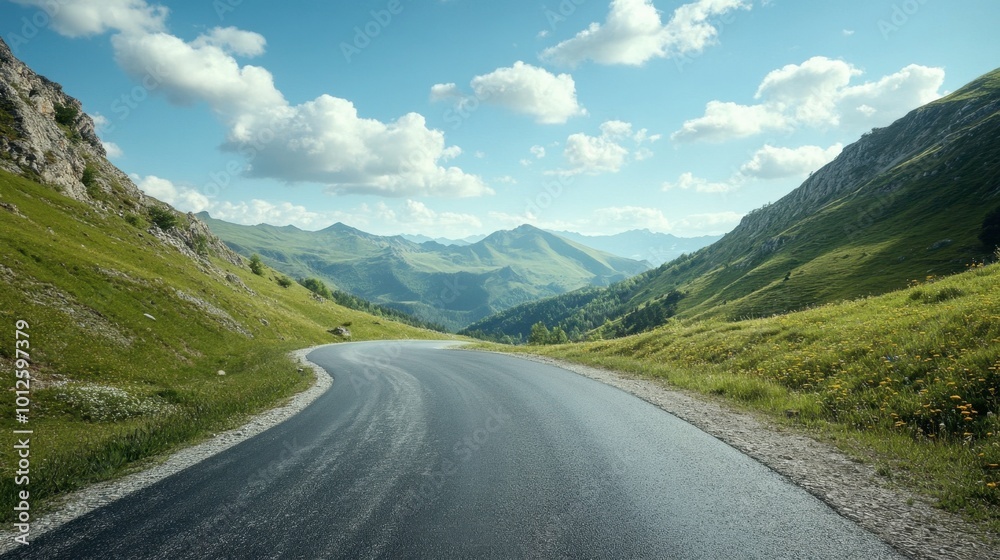 Naklejka premium A winding asphalt road with green mountains on either side, under a bright sky and scattered clouds on a sunny afternoon.