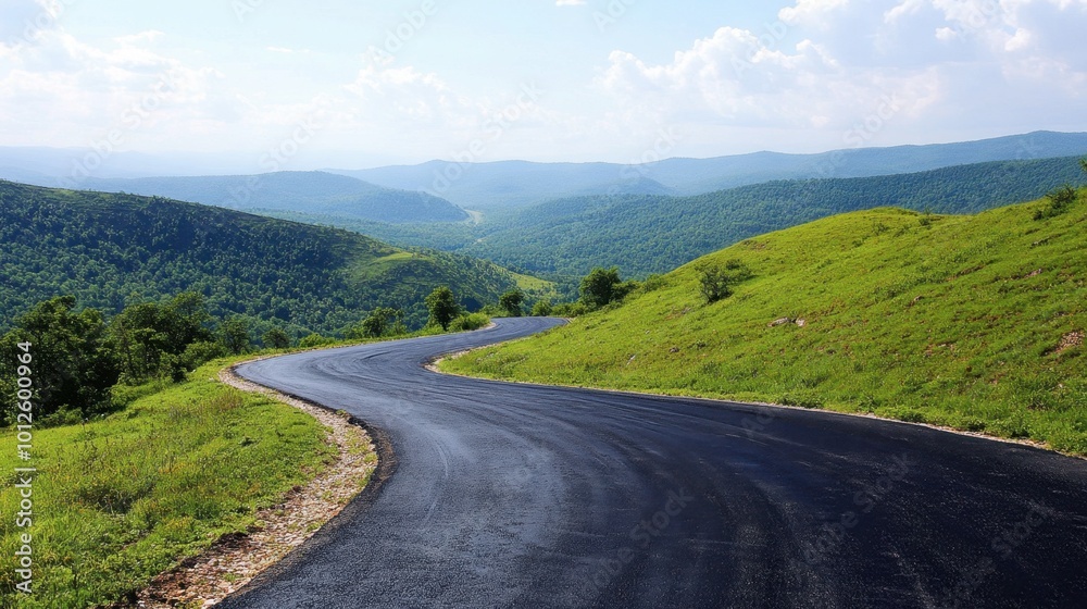 An asphalt road curving through green mountain terrain, under a clear sky with gentle, scattered clouds on a sunny day. An asphalt road curving through green mountain terrain, under a clear sky with gentle, scattered clouds on a sunny day.