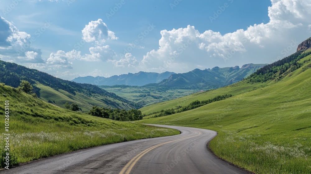 An asphalt road winding through green mountain valleys, with a clear sky and soft white clouds on a sunny, bright day. An asphalt road winding through green mountain valleys, with a clear sky and soft white clouds on a sunny, bright day.
