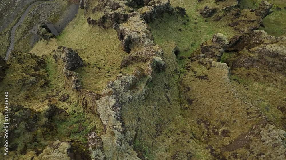 Aerial shot of jagged, moss-covered volcanic ridges in northern Iceland, showcasing the region's unique geology and untouched natural landscape. Aerial shot of jagged, moss-covered volcanic ridges in northern Iceland, showcasing the region's unique geology and untouched natural landscape.