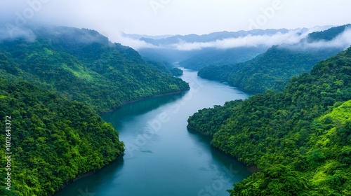 A gentle river flows through a vibrant green valley, mountains in the background, enveloped in mist. Calm. Tranquility abounds. Real Beauty Landscape Concept