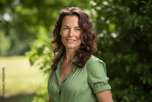 Portrait of beautiful middle aged woman smiling at camera in the park