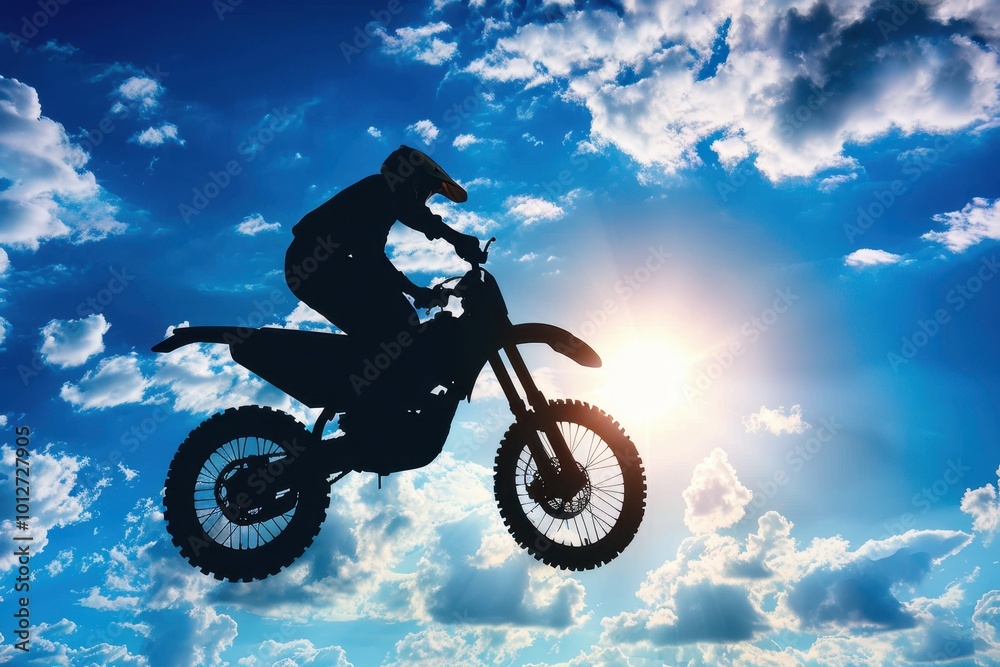 Motocross jump silhouette against sunny blue sky Motocross jump silhouette against sunny blue sky