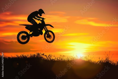 Motocross silhouette jumping over sunset light