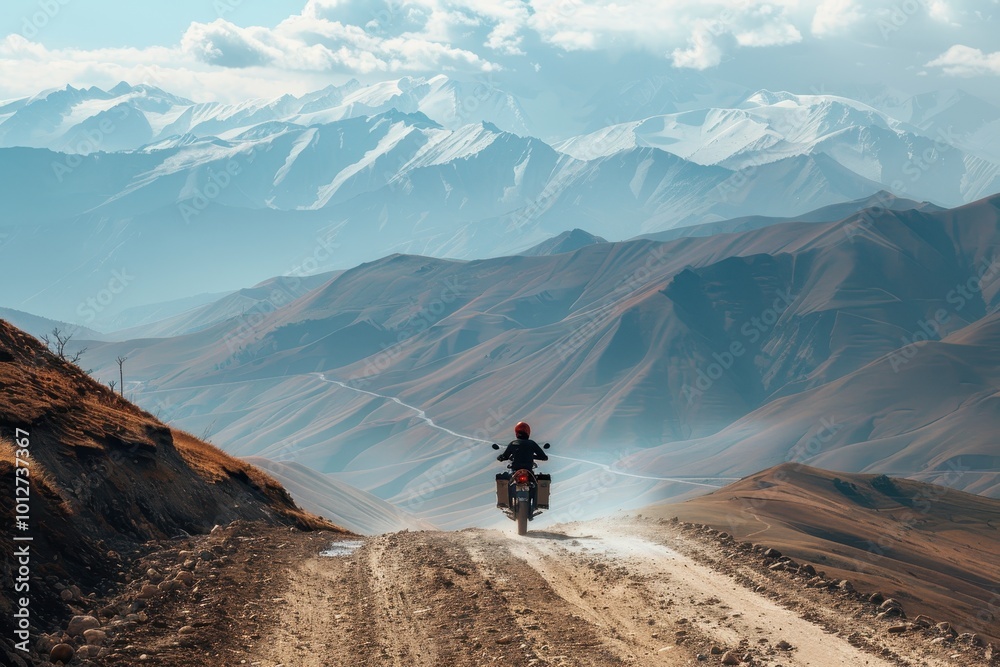 Fototapeta premium Motorcyclist on mountain dirt roads Adventure touring concept