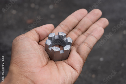 Silver castle nut holding on hand