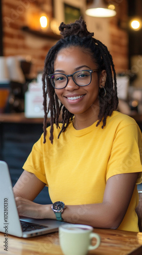 African-American woman glasses sitting table cafe working laptop