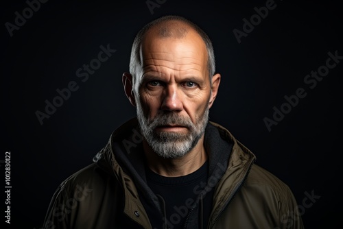 Portrait of a middle-aged man with a beard on a dark background.