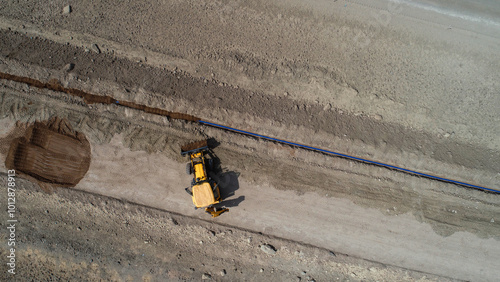 laying fiber cable line under the road with mini excavator photo