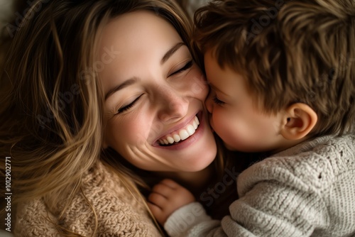 Mother enjoying playful moments with her children as her son lovingly kisses her cheek