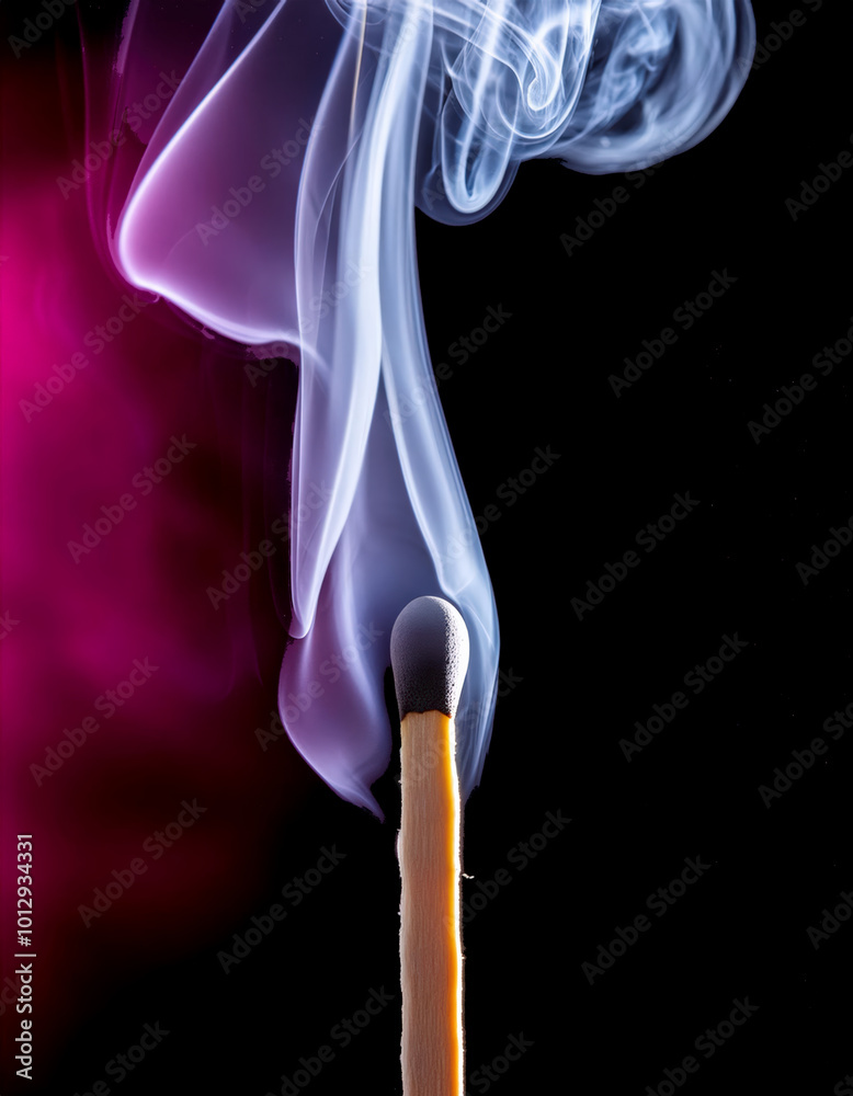 A burned matchstick with a wispy trail of smoke isolated on dark background.