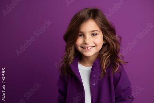 portrait of smiling little girl in violet hoodie over purple background