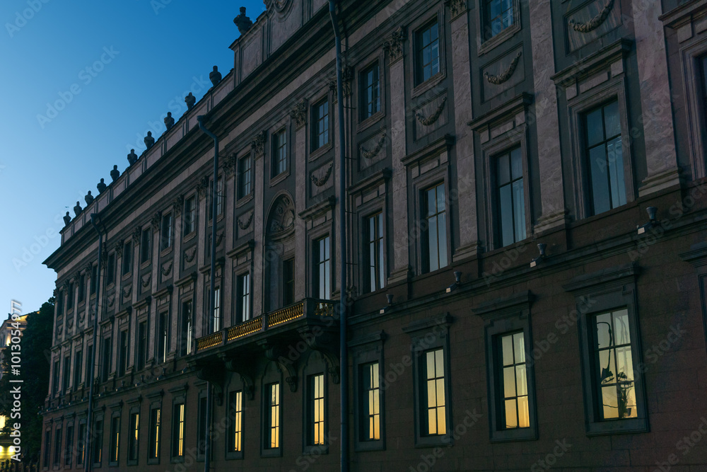 Obraz premium architectural background, dark facade of an old city building, barely illuminated by the morning sun rays