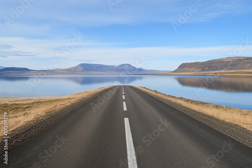 A long road with a yellow line down the middle. The road is empty and the sky is clear