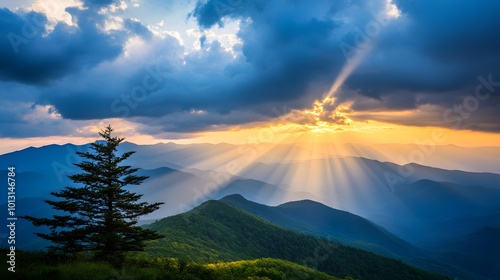 The sun shines through the clouds, casting rays of light on mountains and green grass in mountainous areas