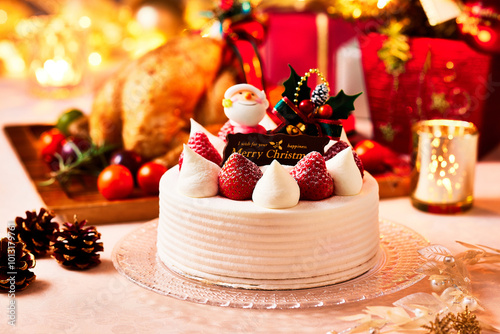 クリスマスケーキ、ガラス製のお皿に生クリームとイチゴのケーキ黄金に輝く贅沢なイメージ