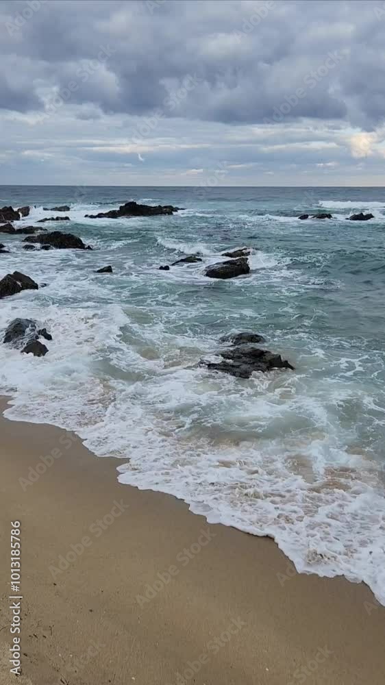 Strong waves hit the rocky beach on a dark cloudy day at Jeongdongjin beach in Gangwondo Province, South Korea. Strong waves hit the rocky beach on a dark cloudy day at Jeongdongjin beach in Gangwondo Province, South Korea.