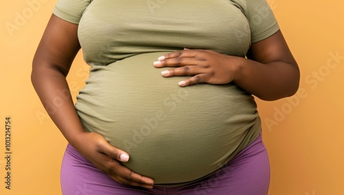 Closeup of Pregnant Woman's Big Round Belly in Green Shirt and Shorts