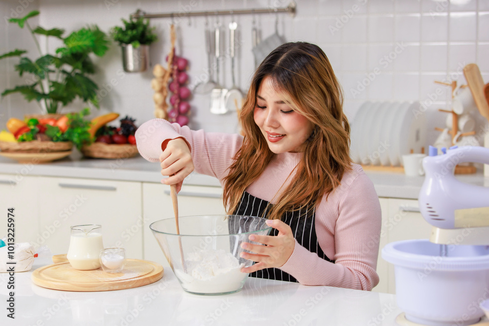Young happy Asian beautiful woman, female wearing aprons intends to knead the dough mixing for baking cakes and making homemade bread and desserts. Lifestyle enjoy weekends cooking in kitchen at home Young happy Asian beautiful woman, female wearing aprons intends to knead the dough mixing for baking cakes and making homemade bread and desserts. Lifestyle enjoy weekends cooking in kitchen at home