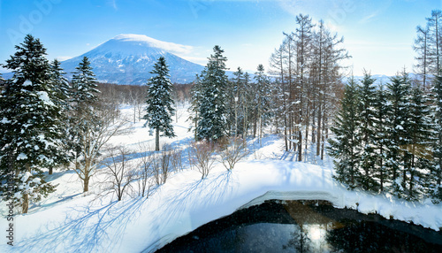 Panorama view of Yotei mountain in winter season of snow on tree and onsen pond.