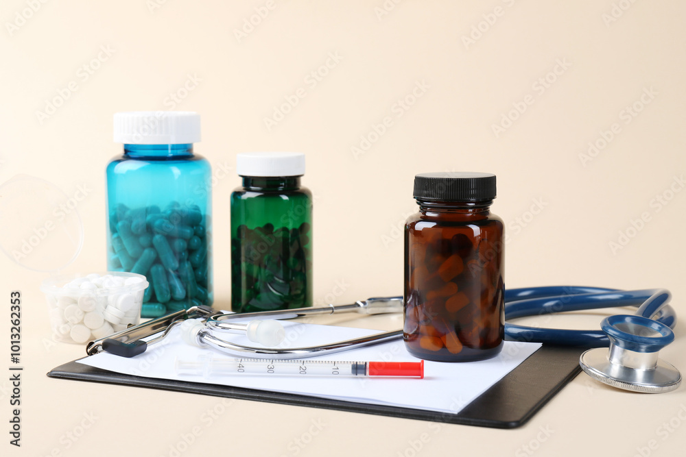 Pharmacist. Pills in plastic bottles, clipboard, syringe and stethoscope on beige background Pharmacist. Pills in plastic bottles, clipboard, syringe and stethoscope on beige background