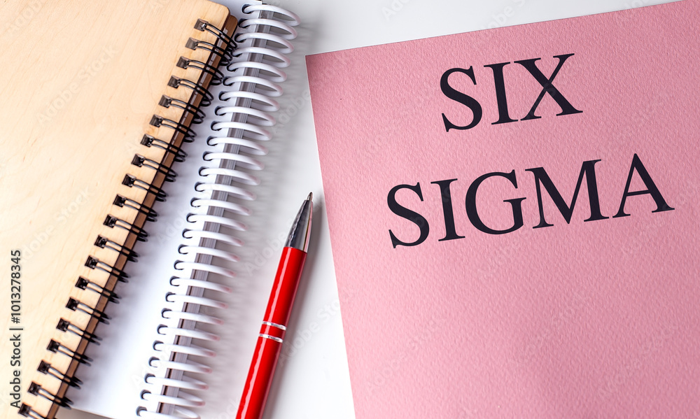 Six Sigma concept with notebooks and red pen on white background Six Sigma concept with notebooks and red pen on white background