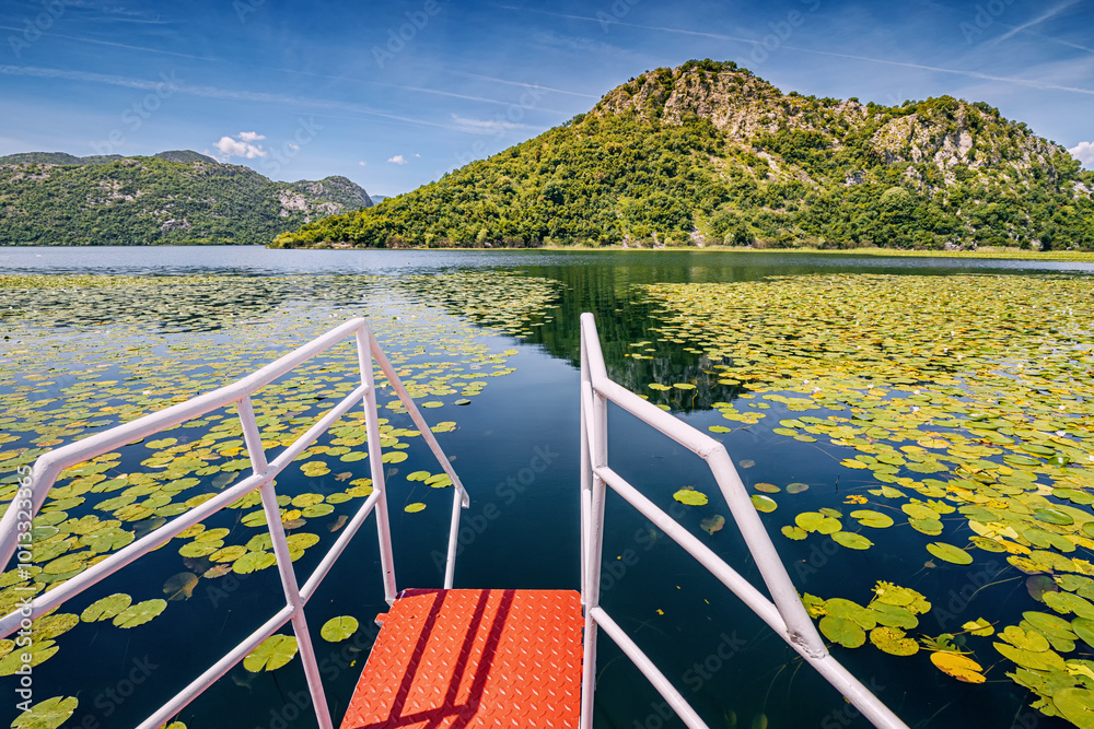 Serene boat tour on Skadar Lake, Montenegro, amidst Balkan mountains.