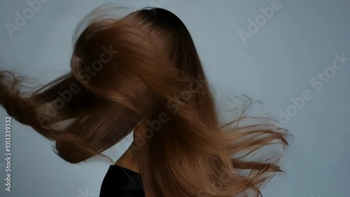 A woman with long, flowing brown hair flips her head back, showcasing hair care beauty