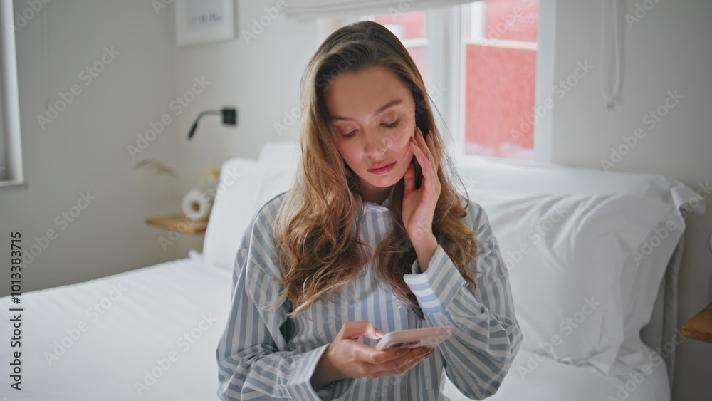 Depressed girl reading cellphone message in cozy bedroom closeup. Serious woman Depressed girl reading cellphone message in cozy bedroom closeup. Serious woman
