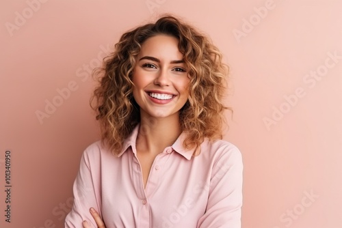 Portrait of a beautiful young woman with curly hair on pink background