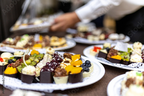 A delightful assortment of desserts served on elegant plates during a festive gathering in a luxurious setting