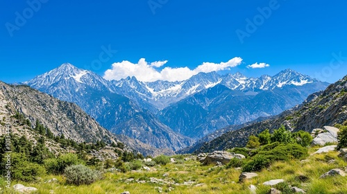 A stunning mountain landscape featuring snow-capped peaks, lush greenery, and a clear blue sky, creating a serene and picturesque natural scene.