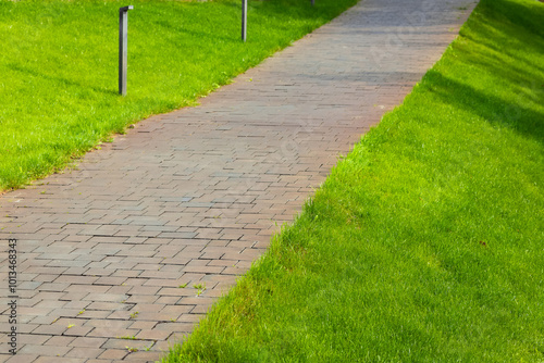 pavement walking side street spring outdoor landscaped design space with green grass lawn idyllic city square and small decorative lantern blurred background