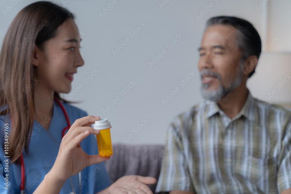 Female doctor is holding a bottle of prescription medicine while explaining dosage and effects to a senior male patient during a home visit Female doctor is holding a bottle of prescription medicine while explaining dosage and effects to a senior male patient during a home visit