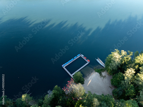 Aerial drone view of people kayaking on a lake surrounded by green forest. Kulka Reserve, Masuria, Poland. Sailing in red kayaks in the Masurian Lake District. Lake Lesk in the Kulka Reserve in Poland photo