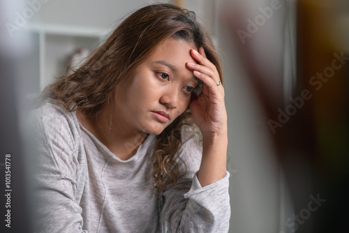 Young Asian woman sitting in a bedroom, feeling sad tired and worried suffering depression in mental health. in concept of depression anxiety and insomnia