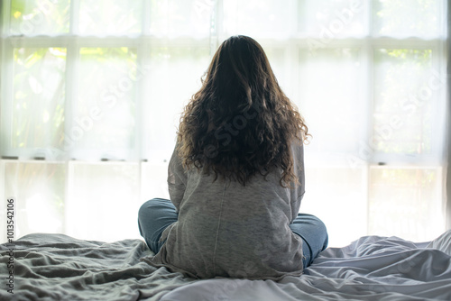 Young Asian woman sitting in a bedroom, feeling sad tired and worried suffering depression in mental health. in concept of depression anxiety and insomnia