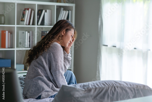 Konstfotografi Young Asian woman sitting in a bedroom, feeling sad tired and worried suffering depression in mental health