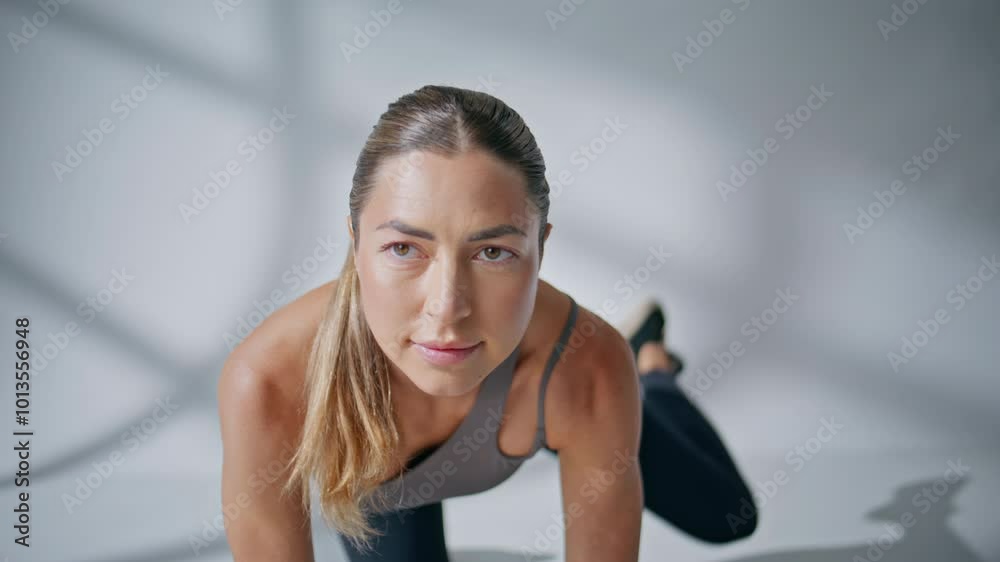 Sport trainer showing exercises white wall background closeup. Girl raising leg Sport trainer showing exercises white wall background closeup. Girl raising leg