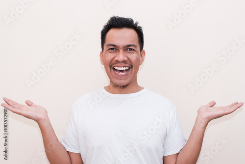 Smiling a Southeast Asian man both palms open on Isolated on white background. Creative people can put the product they want into the hands of men.