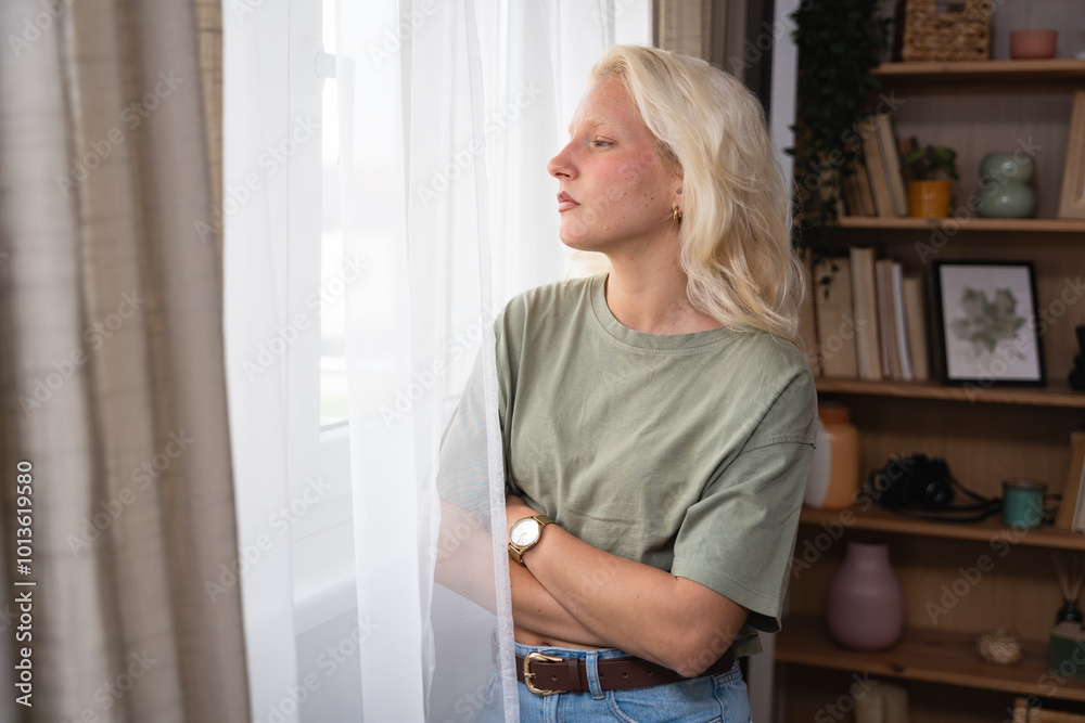 Young woman living alone in apartment looking out the window spying on new neighbors moving into house or apartment across the street from hers. Curious girl watches the people passing by her property Young woman living alone in apartment looking out the window spying on new neighbors moving into house or apartment across the street from hers. Curious girl watches the people passing by her property