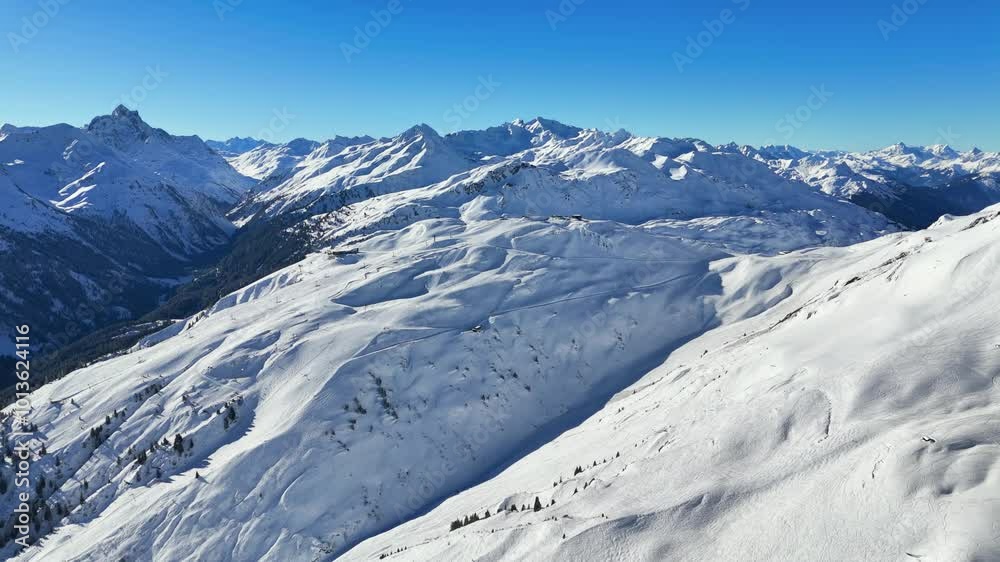 St Anton am Arlberg, Austria: Aerial view of famous ski resort, breathtaking winter panorama of snow-covered Alpine mountains, sunny day with clear blue sky - landscape panorama of Europe from above
St Anton am Arlberg, Austria: Aerial view of famous ski resort, breathtaking winter panorama of snow-covered Alpine mountains, sunny day with clear blue sky - landscape panorama of Europe from above