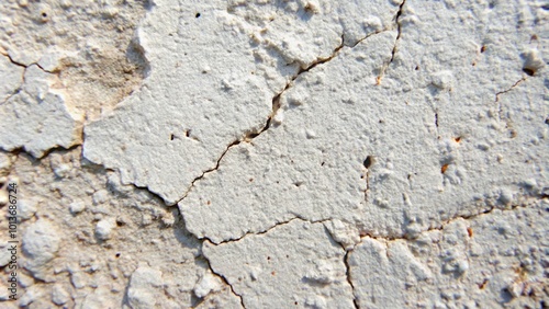 Close-up of a cracked and weathered white painted wall surface.