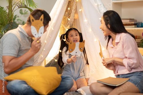 Valokuva Cheerful Asian family enjoys playtime together, using animal masks during fun role-playing activity