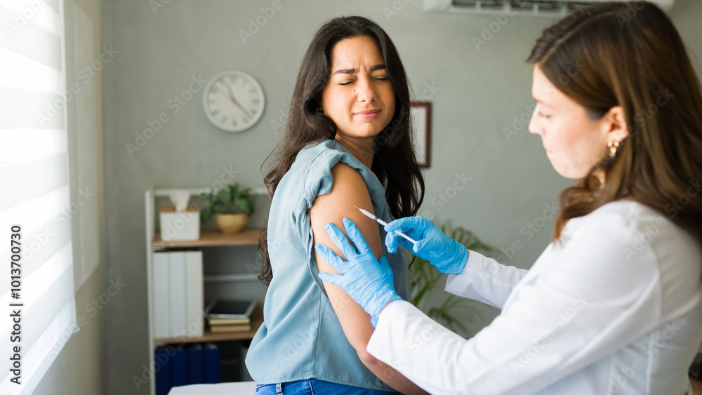 Woman doctor administers a vaccine to a young female patient at a medical clinic Woman doctor administers a vaccine to a young female patient at a medical clinic