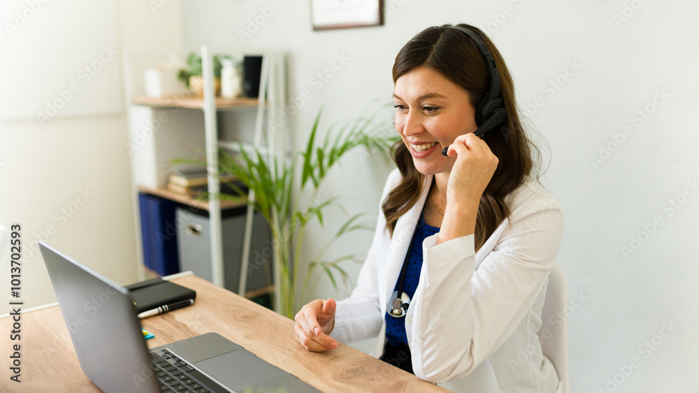 Female physician chats with a patient via video call, wearing a headset and smiling Female physician chats with a patient via video call, wearing a headset and smiling