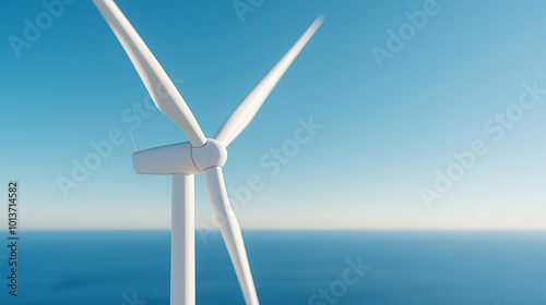 Close-up of wind turbine with blue sky and sea in background. Renewable energy concept by the ocean